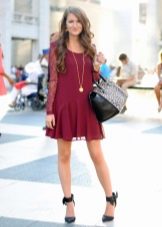 Burgundy dress in combination with black shoes and a bag