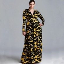 Geltona ir juoda ilga suknelė su gilia iškirpte ir ilgomis rankovėmis apkūniai