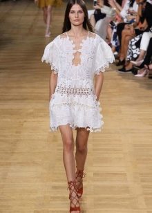 Λευκό τουνίκ φόρεμα με τελειότητα στην επίδειξη μόδας