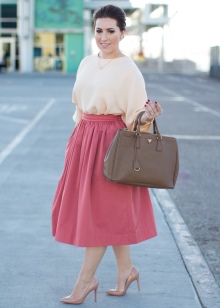 Ružičasta puna suknja ispod koljena u kombinaciji s bluzom boje breskve