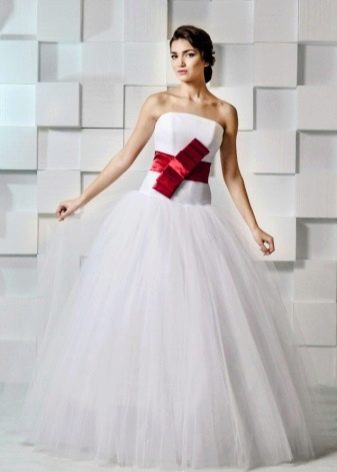Gaun pengantin dengan busur merah diikat di tengah