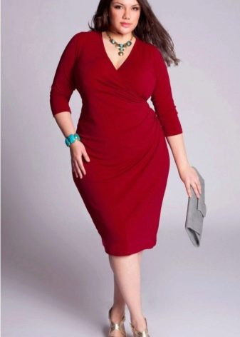 ผู้หญิงอวบอ้วนในชุดสีแดง คลัตช์สีเทาและรองเท้าแตะสีทอง
