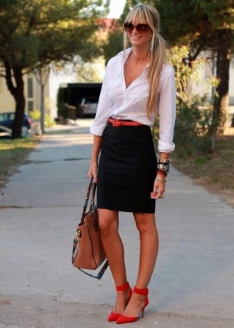 Falda lápiz negra combinada con una camisa blanca y zapatos rojos.