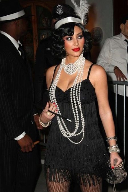 Robe Gatsby noire associée à des perles et un petit sac à main